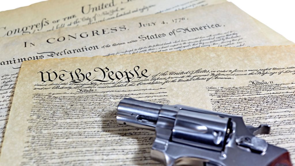 The US Constitution and a revolver acting as a paperweight.