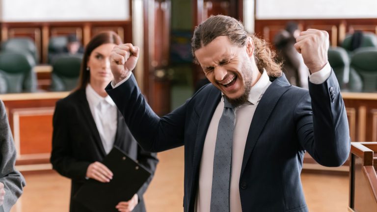 A lawyer celebrating a victory in a courtroom.