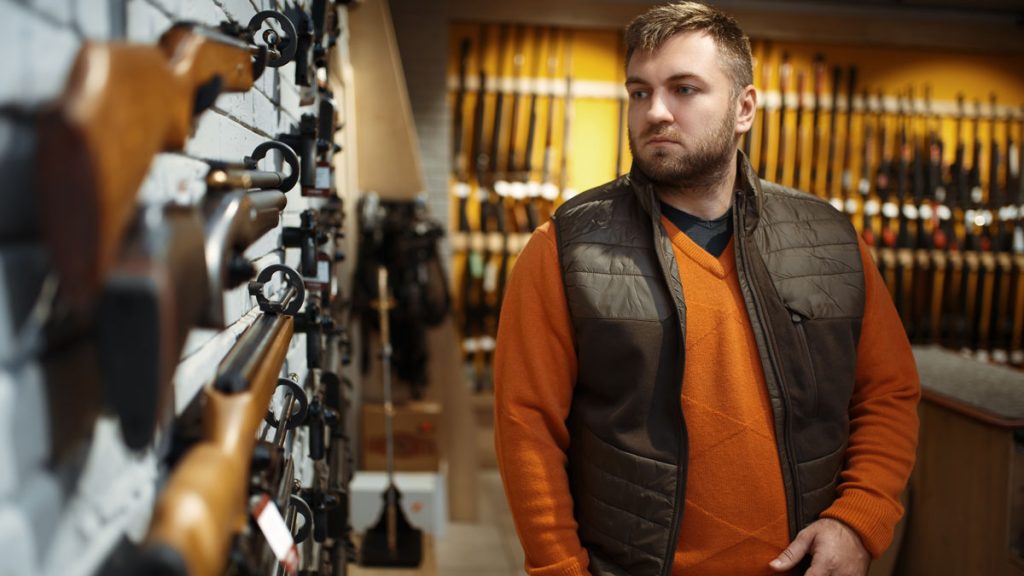 A man working at a gun shop retail counter